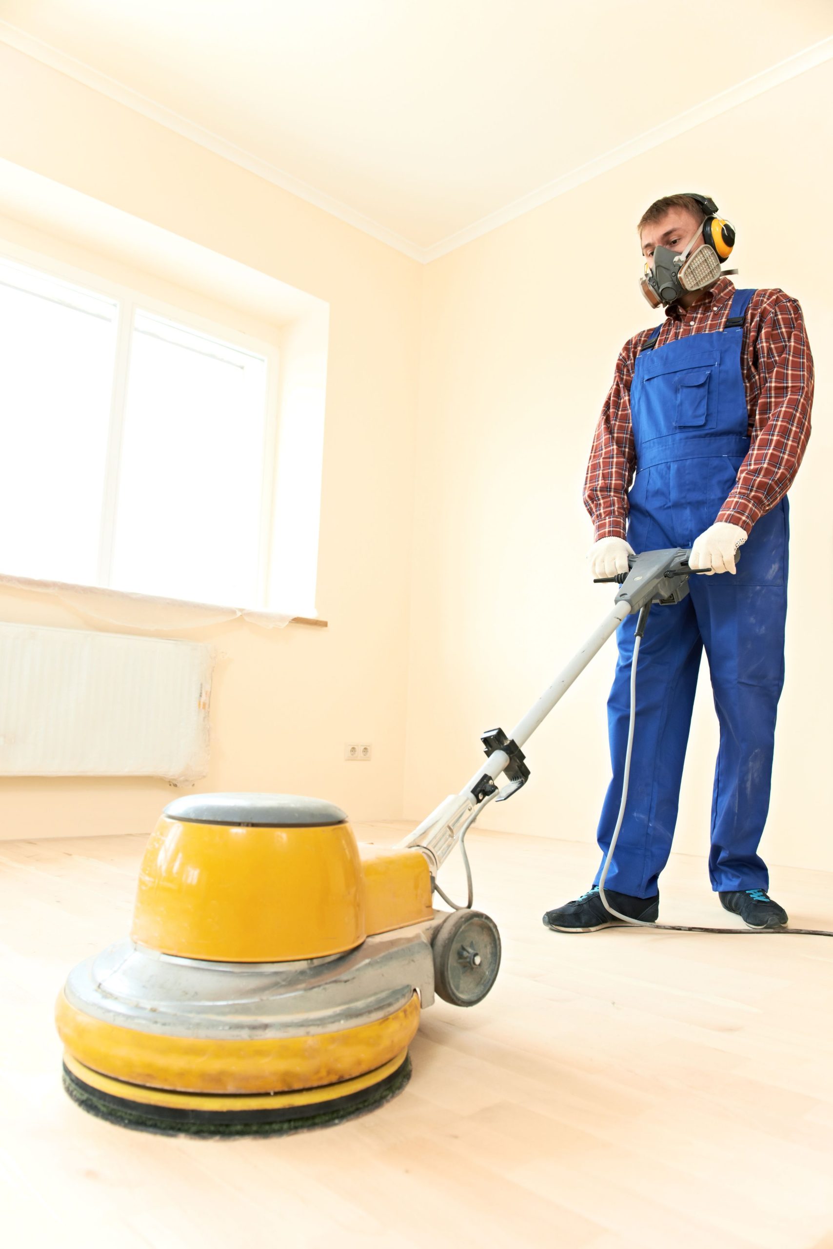 21807508_xl-Worker-carpenter-doing-parquet-Wood-Floor-maintenance-work-by-grinding-machine-scaled